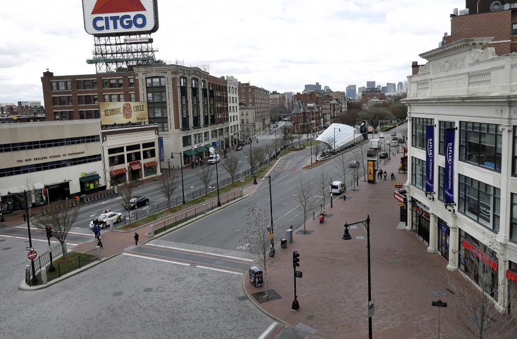 The usually busy Kenmore Square in Boston is virtually deserted at lunchtime Friday, April 19, 2013, during a call for "shelter-in-place" for Boston and some area communities. Two suspects in the Boston Marathon bombing killed an MIT police officer, injured a transit officer in a firefight and threw explosive devices at police during their getaway attempt in a long night of violence that left one of them dead and another still at large Friday, authorities said as the manhunt intensified for a young man described as a dangerous terrorist. (AP Photo/Elise Amendola)